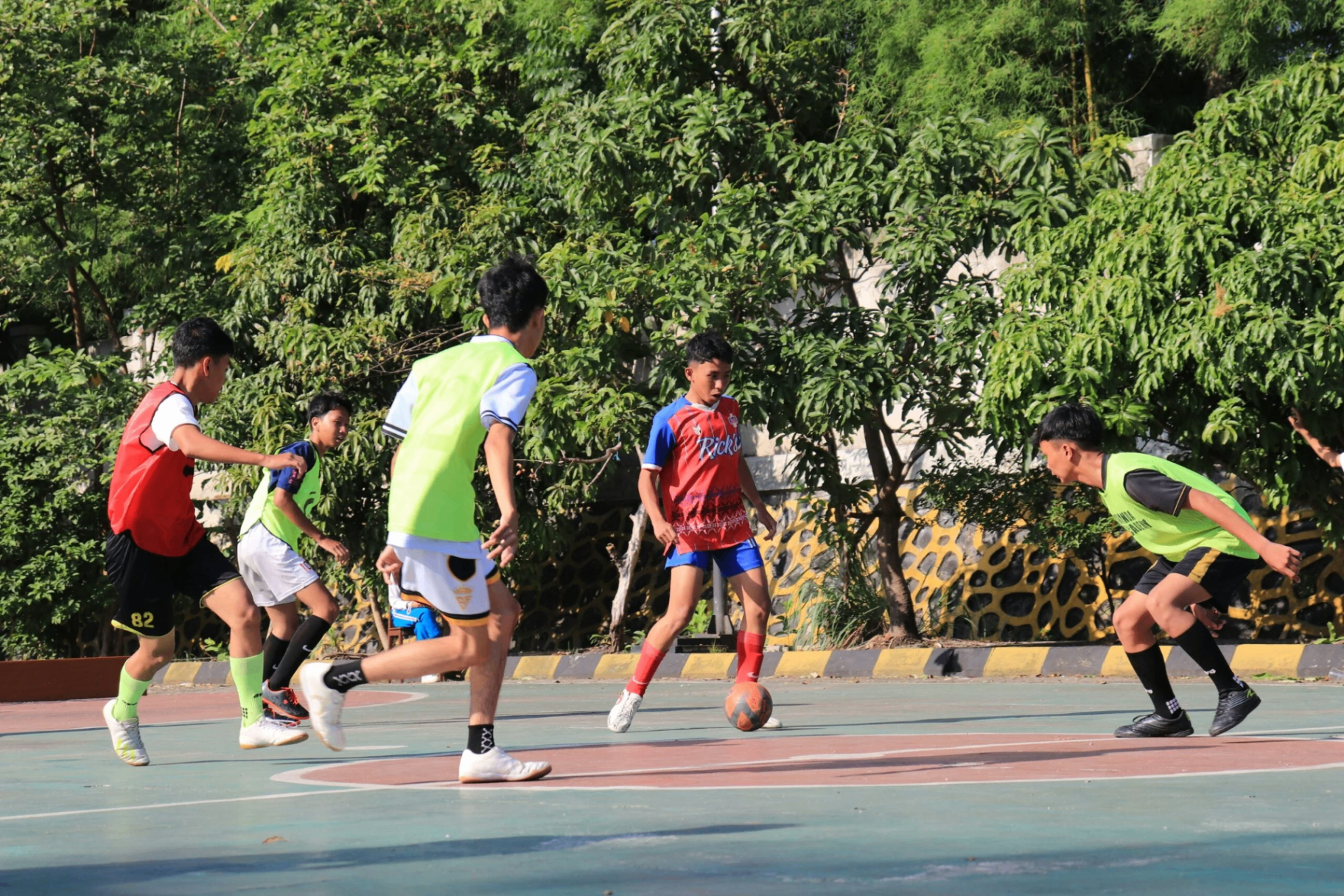 Jeunes joueurs de foot en plein match sur un terrain extérieur